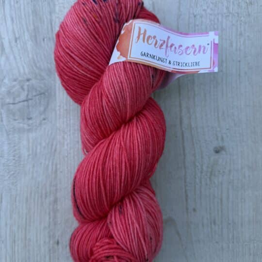 Herzfasern No. 21 Korallenherz – handgefärbtes Garn aus extrafeiner Merinowolle und Polyamid in Koralle, Himbeerrosa, Pink und feinen dunklen Sprenkeln.